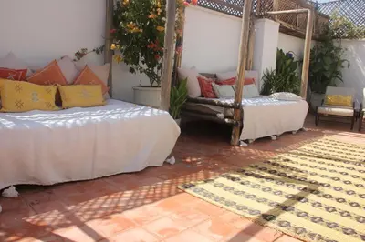 a bedroom with two beds and a rug at Riad Dar Nael in Marrakech