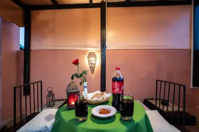 a table with a bottle of soda and a plate of food at Riad Azcona in Marrakech
