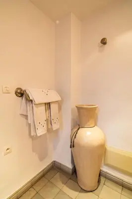 a vase in a room with towels on the wall at Riad Azcona in Marrakech