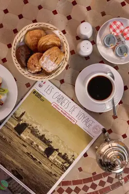 a table with a basket of pastries and a cup of coffee at Kenzi Menara Palace & Resort in Marrakech
