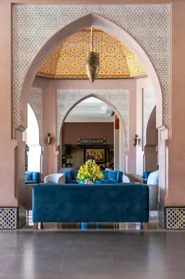 a lobby with a blue couch in a building at Kenzi Menara Palace & Resort in Marrakech