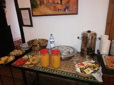a table with a bunch of food and orange juice at Riad Karmela in Marrakech