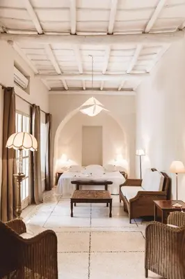 a hotel room with a bed and a table and chairs at Les Deux Tours in Marrakech