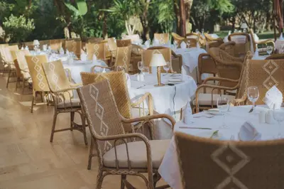 a row of tables and chairs with white tablecloths at Les Deux Tours in Marrakech