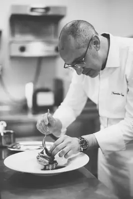 a man in a kitchen eating food on a plate at Les Deux Tours in Marrakech