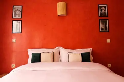 a bedroom with a white bed with an orange wall at Bright Apt in the Heart of Marrakech-Walk Everywhere in Marrakech