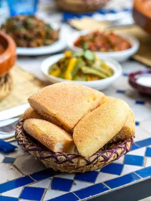 a basket of sandwiches on a table with plates of food at Riad Sheba in Marrakech