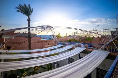 a group of white benches with a bridge in the background at Riad Sheba in Marrakech
