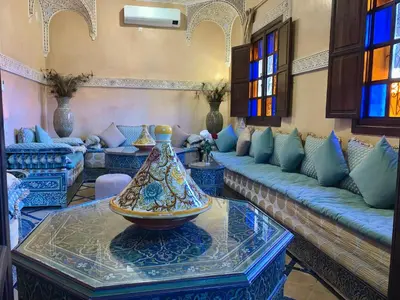 a living room with couches and a vase on a table at Riad Mazal in Marrakech