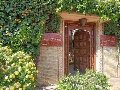 an entrance to a garden with a door and flowers at Riad Mazal in Marrakech