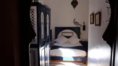 a small bedroom with a bed with white sheets at Riad Nafis in Marrakech