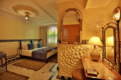 a bedroom with a bed and a mirror and a table at Riad Catalina in Marrakech