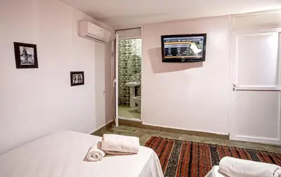 a bedroom with a bed and a tv on the wall at Hotel Agnaoue in Marrakech