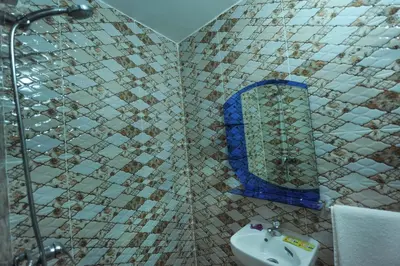 a tiled bathroom with a sink and a mirror at Hotel Agnaoue in Marrakech