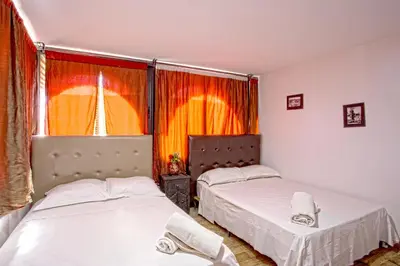 two beds in a small room with a window at Hotel Agnaoue in Marrakech