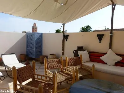 a patio with chairs and a couch under a tent at Riad Bel Haj in Marrakech
