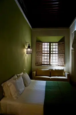 a bedroom with a bed and a window at Riad Tzarra in Marrakech