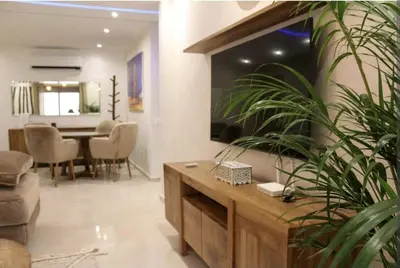 a living room with a table and a dining room at COSY APPART avec 2 piscines, 2 CH, 2 SDB Marrakech in Marrakech