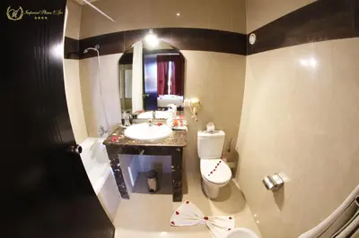a bathroom with a sink and a toilet and a mirror at Hotel Imperial Plaza & Spa in Marrakech