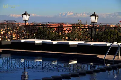 a swimming pool with lounge chairs and a view of the mountains at Hotel Imperial Plaza & Spa in Marrakech