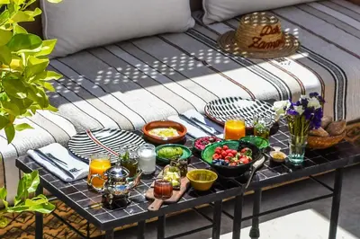 a table with food and drinks on top of a bench at Riad Dar Zaman in Marrakech