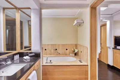 a bathroom with a tub and a sink at Hôtel & Ryads Barrière Le Naoura in Marrakech
