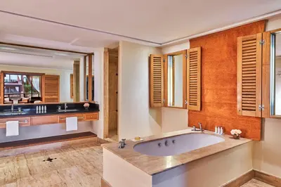 a bathroom with a tub and two sinks at Hôtel & Ryads Barrière Le Naoura in Marrakech