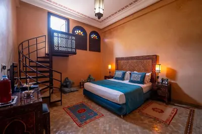 a bedroom with a bed and a spiral staircase at Al Fassia Aguedal in Marrakech
