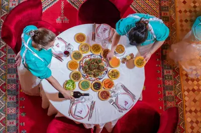 two women standing at a table with a plate of food at Al Fassia Aguedal in Marrakech