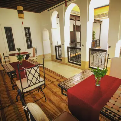 a living room with a table and chairs in a building at Riad Les 5 Soeurs in Marrakech