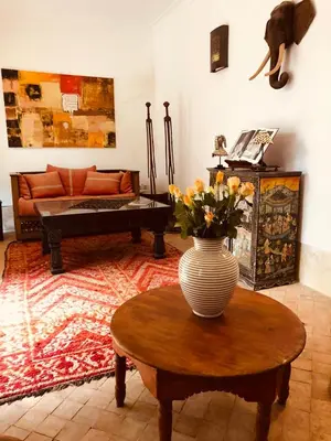 a living room with a vase of flowers on a table at Riad Les 5 Soeurs in Marrakech