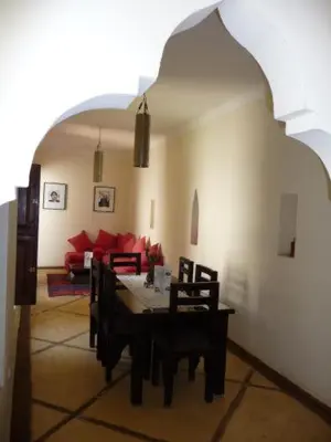 a living room with a table and a couch at Riad Al Faras in Marrakech