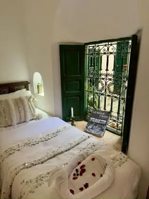 a bedroom with a bed and a window with a gate at Riad Al Karama in Marrakech