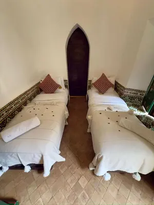 a group of four beds in a room at Riad Al Karama in Marrakech