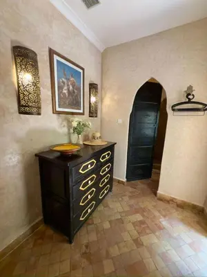 a room with a dresser and a black door at Riad Al Karama in Marrakech