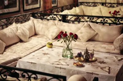 a bed with a table with a vase of flowers on it at Riad Dar Justo Hotel Boutique & Spa in Marrakech