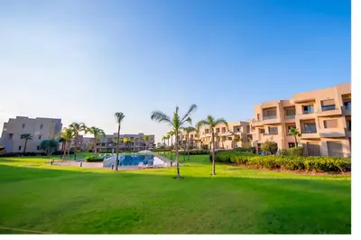 a park in front of a large apartment complex at Ehden Properties - Appt luxueux dans la residence golfique Prestigia Argan in Marrakech