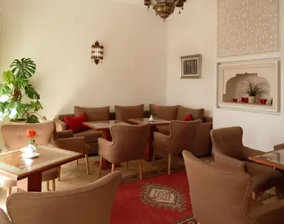 a restaurant with tables and chairs in a room at Riad Carina in Marrakech