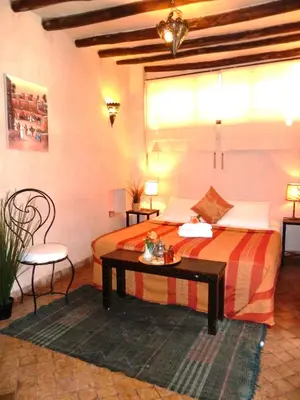 a hotel room with a bed and a table at Riad Carina in Marrakech
