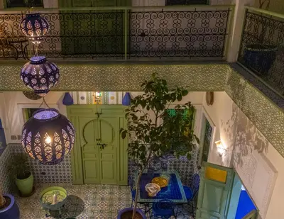 a room with a green door and a table and lights at Riad Med Agorà in Marrakech