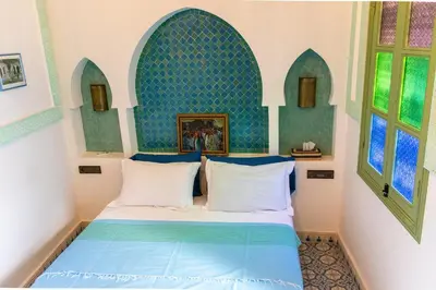 a bedroom with a bed with a blue headboard at Riad Med Agorà in Marrakech