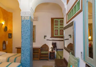 a hotel room with two beds and a mirror at Riad Maison Arabo-Andalouse in Marrakech