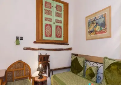 a living room with a couch and a chair at Riad Maison Arabo-Andalouse in Marrakech