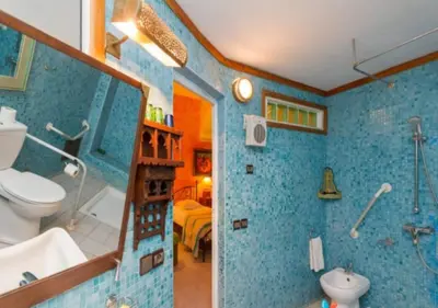 a blue bathroom with a toilet and a sink at Riad Maison Arabo-Andalouse in Marrakech