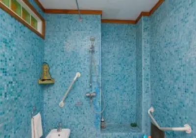 a blue tiled bathroom with a shower and a sink at Riad Maison Arabo-Andalouse in Marrakech