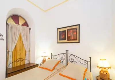 a bedroom with a bed with two lamps and a window at Riad Maison Arabo-Andalouse in Marrakech
