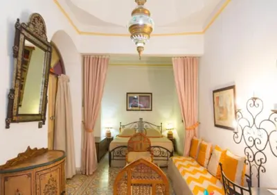 a bedroom with a bed and a couch at Riad Maison Arabo-Andalouse in Marrakech