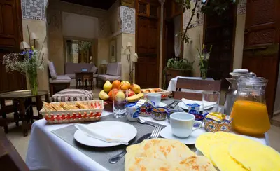 a table with food and fruit on top of it at Riad Dar Zaya in Marrakech