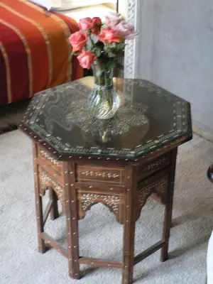 a small table with a vase of flowers on it at Riad Dar Zaya in Marrakech