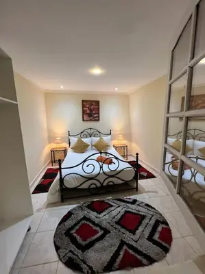 a bedroom with a bed with a rug on the floor at Villa Oasis de la Palmeraie in Marrakech